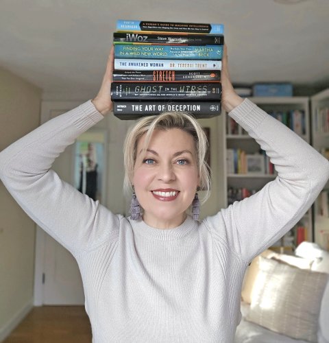 Amy Gray has a stack of books balanced on her head. Each one was written by a former or current New Leaf client. Kartik Hosanagar, Steve Wozniak, Dr. Martha Beck, Dr. Tererai Trend, Scott Sonenshein, Kevin Mitnick.